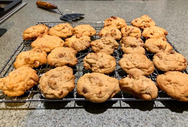 A cooling rack covered in peanut biscuits. 