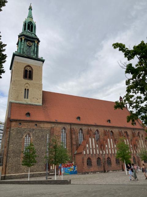 Red-roofed church with tall spire and buttresses