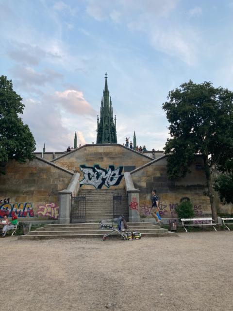 Gothic metal monument at the top of a masonry platform with staircases on two sides