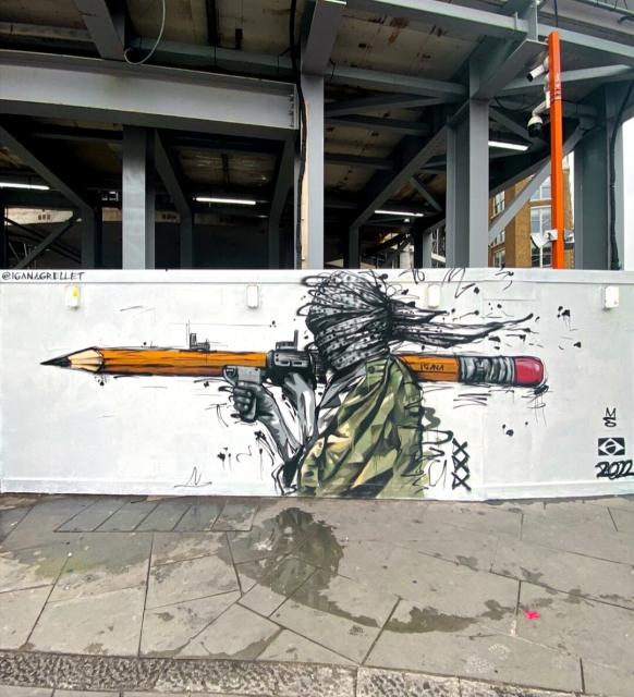 Streetart. Mann trägt übergroßen Bleistift wir eine Waffe. 