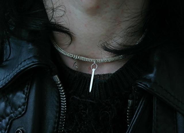 Person with a leather jacket wearing the chain which fits around the neck perfectly