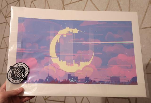 A photo of a print wrapped in plastic.
The print is a digital art of the yellow moon, on the purple clouds, in the blue sky, above the city.