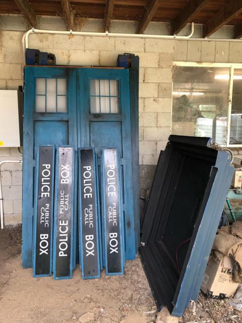 Two disassembled tardis leaning against a wall. 