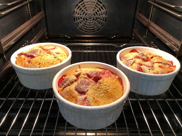 Three medium sized ramkins filled with strawberry clafoutis. 
