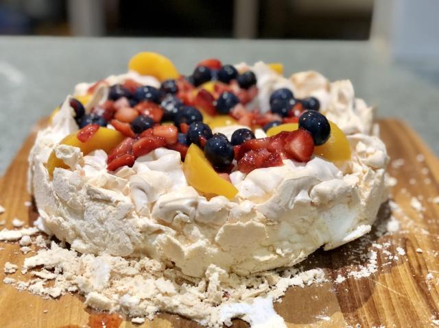 Pavlova topped with peaches, blueberries and strawberries. 