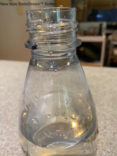 The top of a new style sodastream bottle showing the screw thread and the locking lug below it.