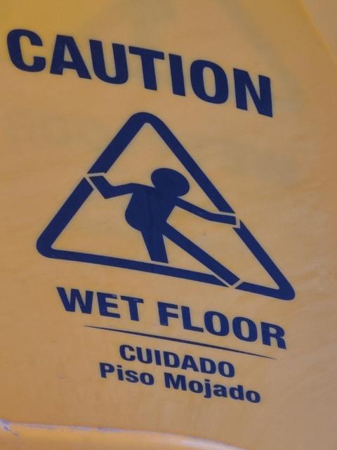 a stick figure on a wet floor sign