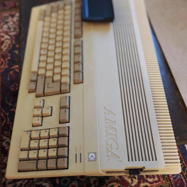 Photograph of an Amiga computer with a small display attached to it and a USB floppy drive emulator.