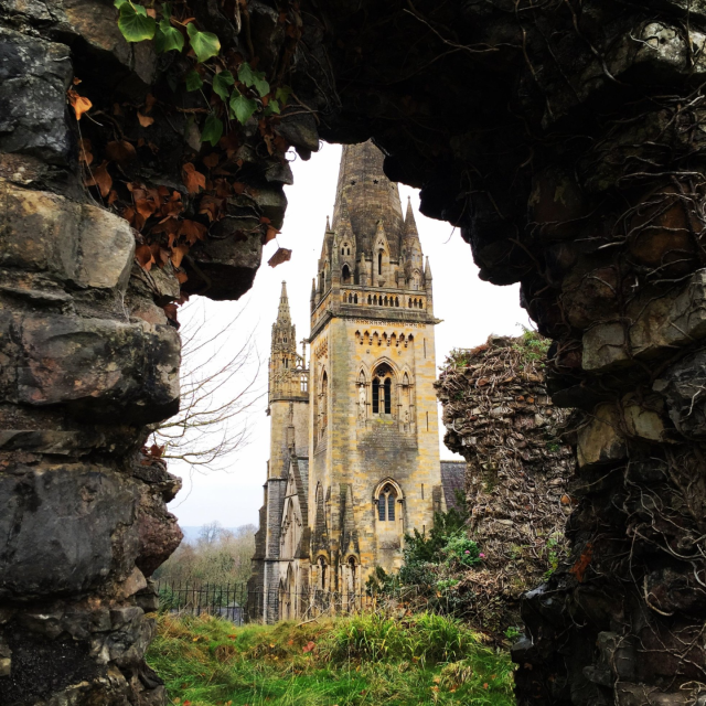 An image of Llandaf Cathedral looking through one of the walls surrounding the cathedral in Autumn.