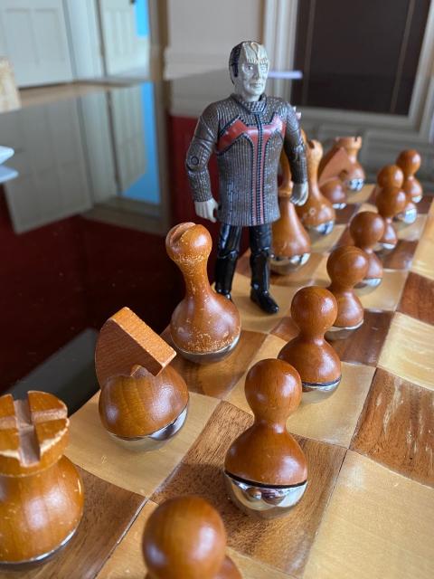 A tiny play figure of Garak from Star Trek: DS9, standing on a chess board