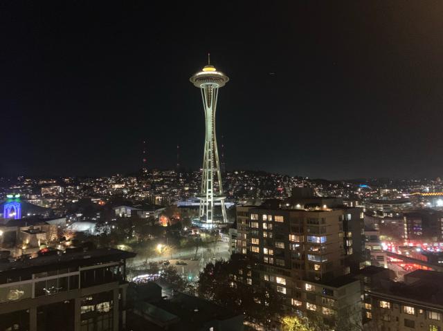 The Seattle Space Needle illuminated in the distance at night.