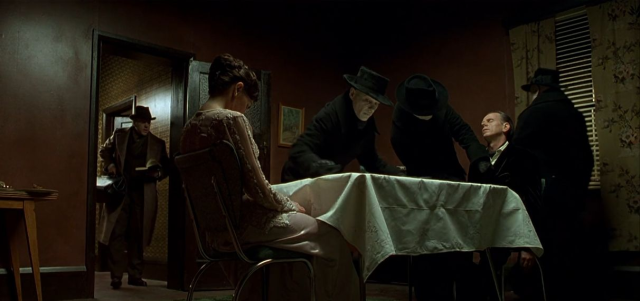 A scene in Dark City where aliens lay down the scene for a dinner scene, architecturing the lives of abducted humans.

Wait, did I just spoil the plot? If so, I'm sorry. It's worth a watch/listen nevertheless.