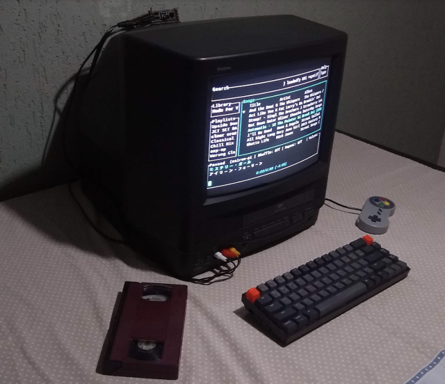 And old V C R television set with a Raspberry Pi in a case on its back and a retro keyboard and gaming controller connected at the front