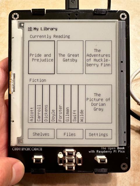 Photo, the Open Book displaying a “My Library” UI with book covers and an ASCII art shelf of fiction.