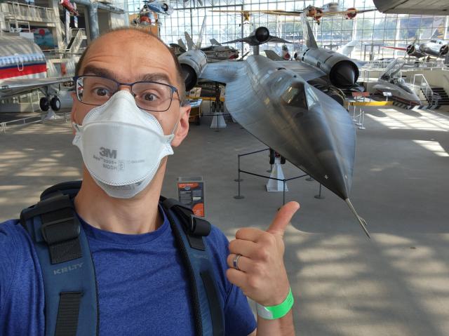 A guy (me) in a 3m aura taking a selfie with a Blackbird in the background at the Boeing Museum of Flight