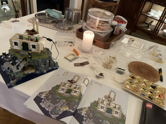 A Lego instruction book, Lego parts and a construction in progress