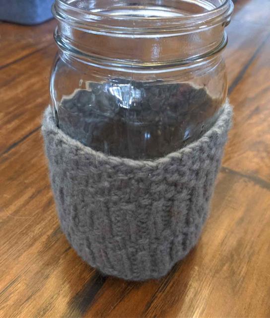 Grey knitted cozy on a quart wide-mouth mason jar.