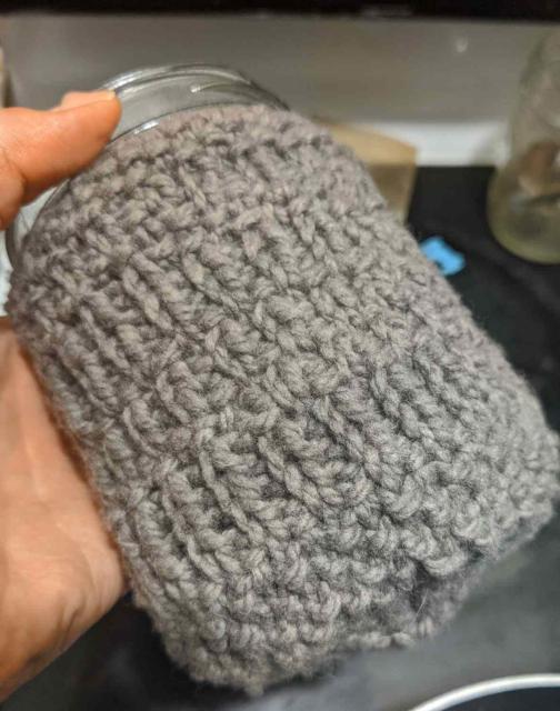 Grey knitted cozy on a half-quart wide mouth mason jar.