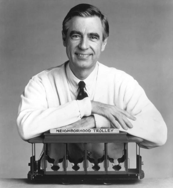 Fred Rogers with arms leaning on the Neighborhood Trolley. Photo by Family Communications Inc./Getty Images