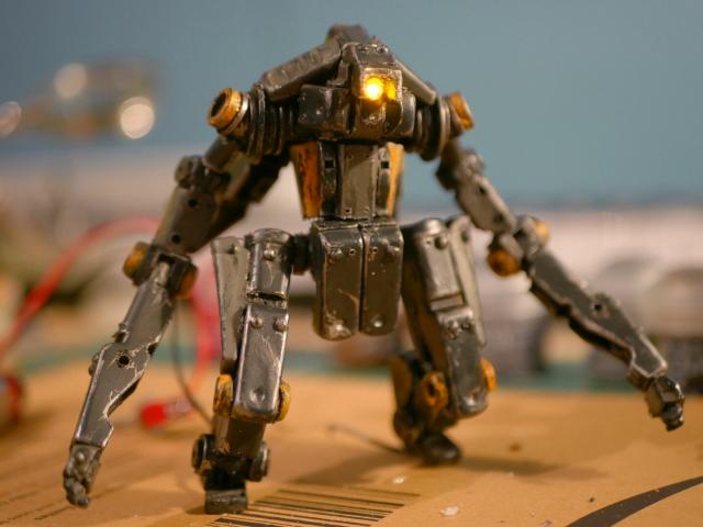 a cyclops robot made from clothespin and bead, it is painted and its unique eye is bright