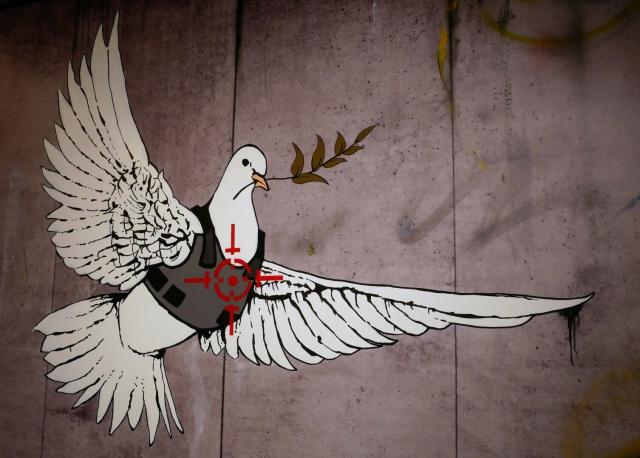 A peace dove with a crosshair on its chest.