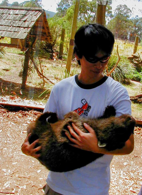 Man holding a wombat like a baby