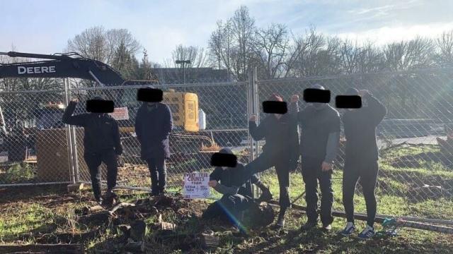 Various people standing in black bloc in front of the former Urban Farm