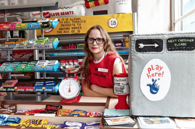Lucy Sparrow at the till of her supermarket art installation...filled with food, toiletries and confectionery items