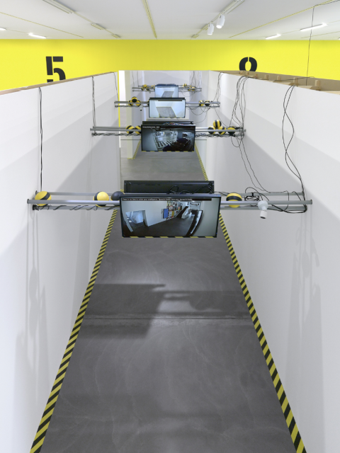 Art installation made of cam output on monitors with striped balls elevated above the ground