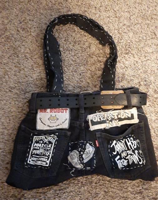 jurse (jort purse), black denim shorts made into a purse with various band patches and hand sewn with waxed dental floss. back side this time 