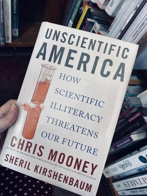 Holding a copy of Unscientific America in a Brisbane library.
