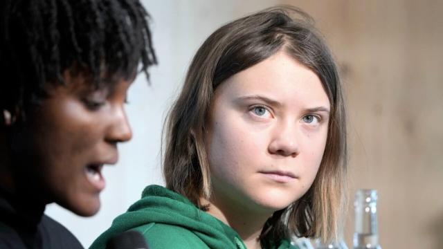 Climate activist Greta Thunberg of Sweden listens to Vanessa Nakate of Uganda at a press conference on January 19, 2023, during the World Economic Forum in Davos, Switzerland. 