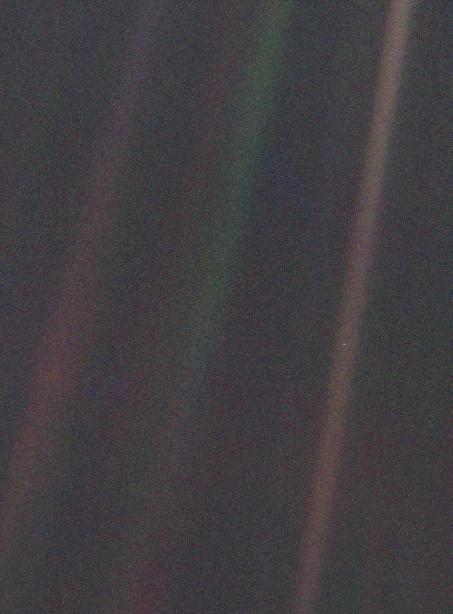 This image of Earth is one of 60 frames taken by the Voyager 1 spacecraft on February 14, 1990 from a distance of more than 6 billion kilometers (4 billion miles) and about 32 degrees above the ecliptic plane. In the image the Earth is a mere point of light, a crescent only 0.12 pixel in size. Our planet was caught in the center of one of the scattered light rays resulting from taking the image so close to the Sun. This image is part of Voyager 1's final photographic assignment which captured family portraits of the Sun and planets. Credit: NASA / JPL
