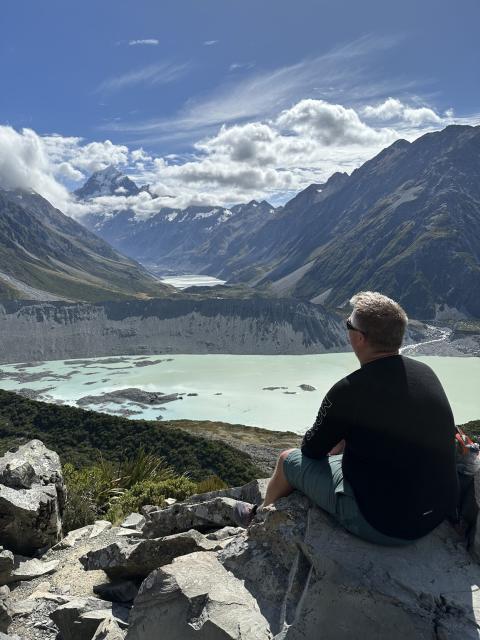 Me sitting on a rock looking at Aoraki / Mount Cook