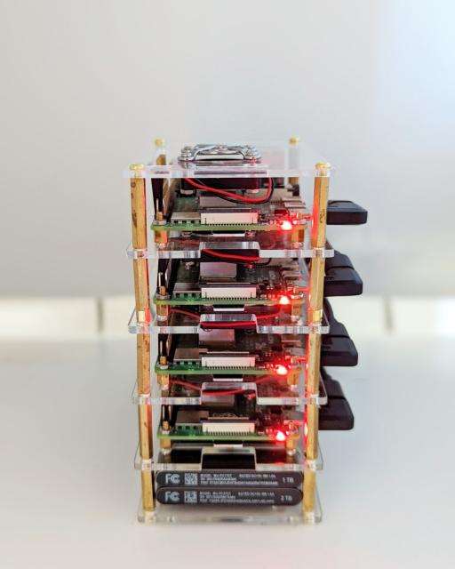 Four raspberry pi computers stacked in an open tower.