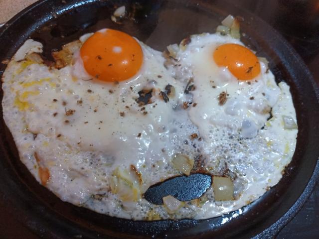 Fried eggs with one yolk extremely large and a large one making a startled face