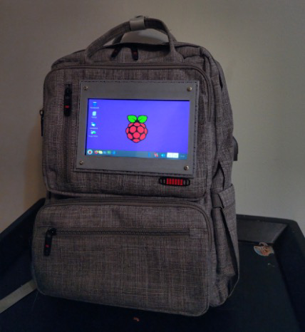 Grey backpack with a screen showing the raspberry pi logo 