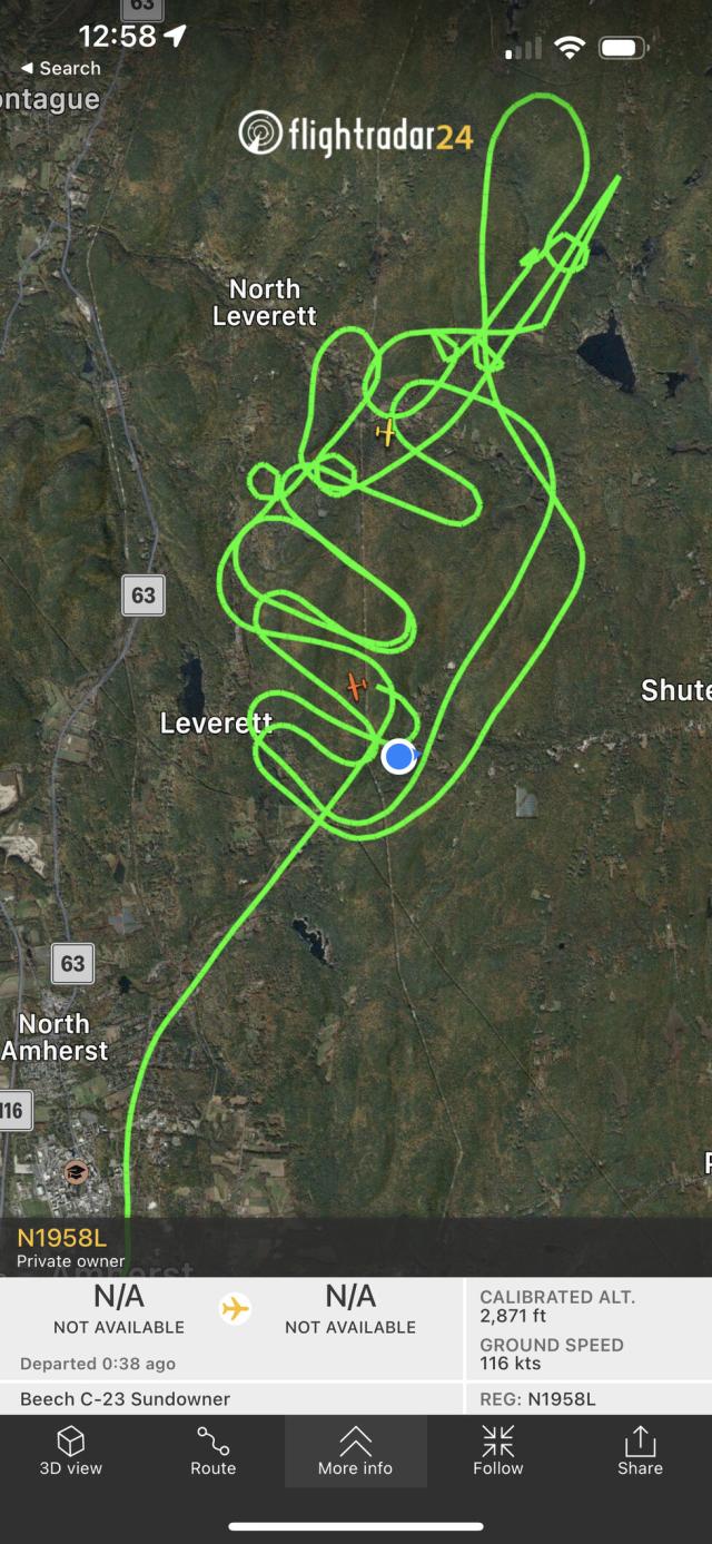 Flight paths on a satellite map showing a forested area with my house represented by a blue dot. That blue dot is right under the loops the plane is making.