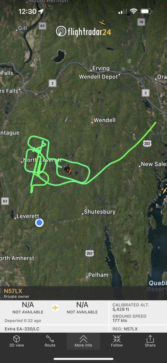 Flight paths on a satellite map showing a forested area with my house represented by a blue dot. That blue dot is right next to the loops the plane is making.
